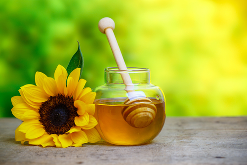 Honey,In,Jar,With,Honey,Dipper,And,Sunflower,On,Wooden